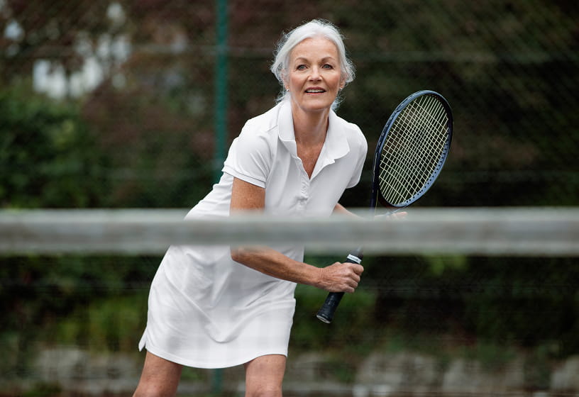 Woman playing tennis on a court with a blurred background